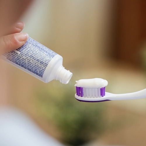 closeup-unrecognizable-woman-applying-toothpaste-toothbrush-bathroom.jpg